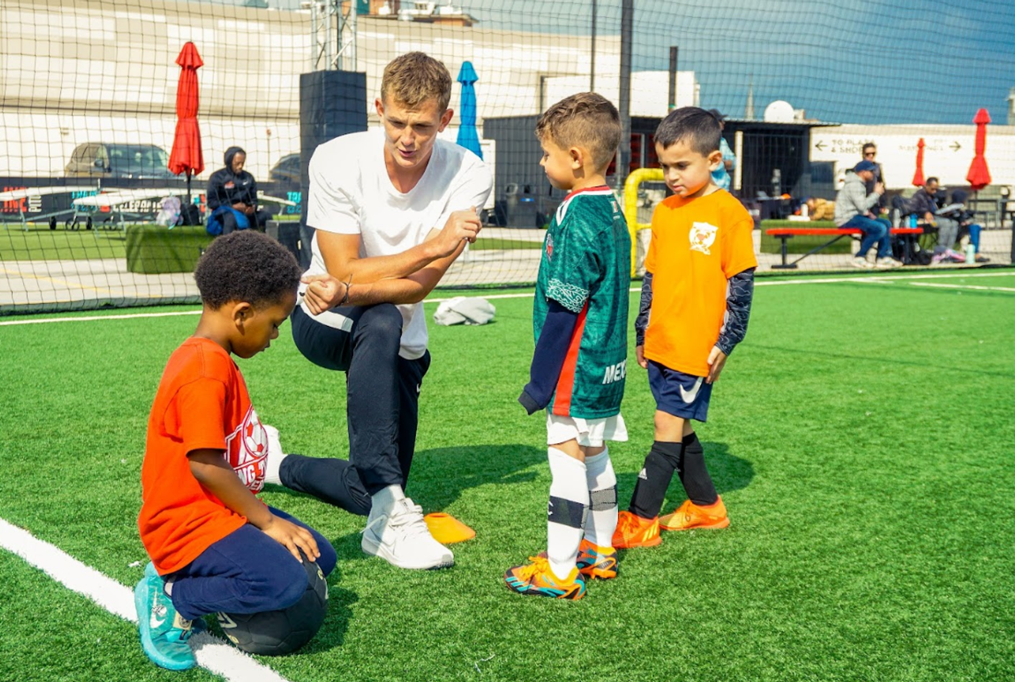 Soccer coach having heart-to-heart talk with youth soccer players. Image by Top Tier Lessons.